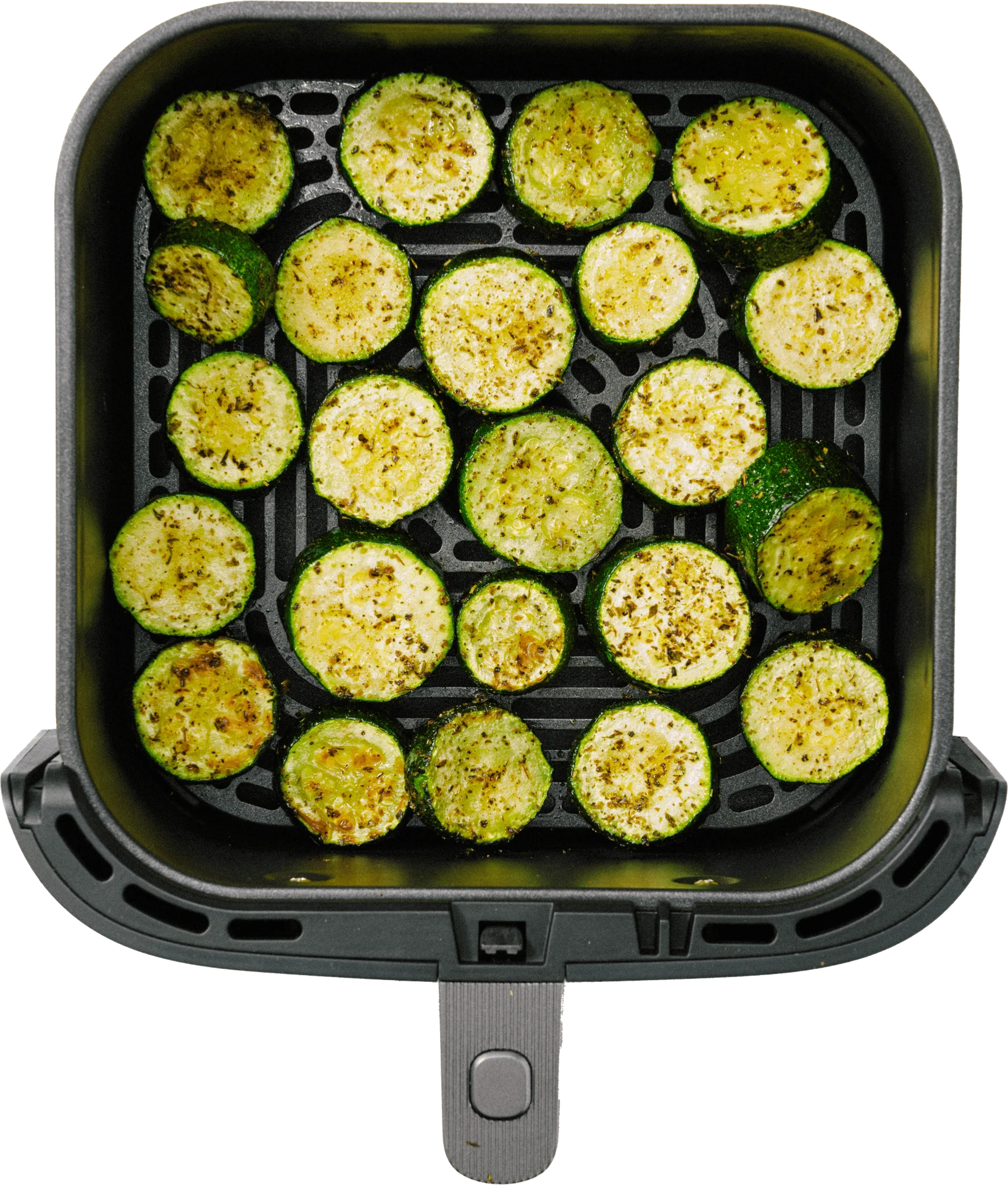 A basket filled with evenly sliced, seasoned zucchini rounds, lightly browned and arranged neatly.